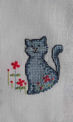 a close up of a cat with flowers on it's chest and an embroidered background