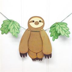 a wooden slotty hanging from a clothes line with leaves on it's sides