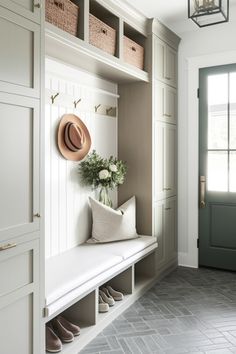 a white bench sitting in front of a window next to a light and some baskets