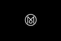 the letter m is inscribed in a circle on a black background with white outlines