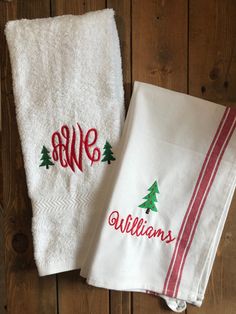 two white towels with embroidered christmas trees on them