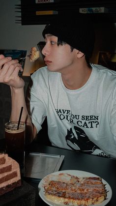 a young man sitting at a table eating food