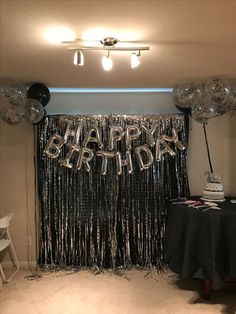 a birthday party with balloons and streamers in the shape of happy birthday written on it