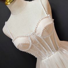 a mannequin wearing a white dress with beading on it