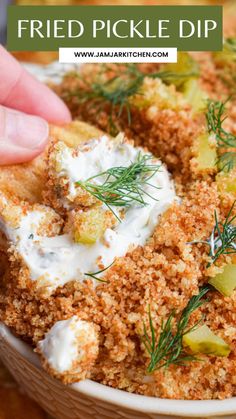 fried pickle dip in a bowl with sour cream and dill sprigs