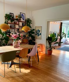 a dining room with wooden floors and lots of plants