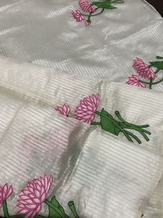 This is a beautiful handloom silk by silk maheswari silk saree in off-white in custom HAND embroidered lotus motif design. Saree is featherlight. It is extremely elegant. Saree pallu is finished with tassels. Falls and pico are done already. Blouse is unstitched and has embroidered lotus motifs. We chose lotus with leaves embroidery to complement the white body of this silk saree. Embroidery was done only in the lower half of the saree,  to maintain the simplicity of the saree, yet adding a pop of colour. Colour may vary slightly depending upon the lighting and individual device settings. Handloom products may have some irregularities unlike power loom products. All sales are final. Dry clean only. White Silk Traditional Wear With Floral Embroidery, White Silk Dupatta With Floral Embroidery, White Silk Fabric With Floral Embroidery, White Chanderi Embroidered Fabric In Traditional Drape, White Silk Fabric With Resham Embroidery, White Embroidered Fabric For Puja And Festive Occasions, White Embroidered Chanderi Saree, White Resham Embroidered Fabric For Puja, White Embroidered Fabric With Resham Embroidery For Puja