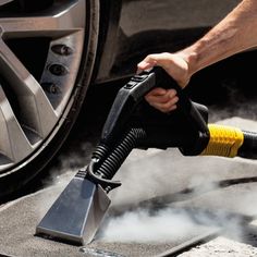 a person is using a vacuum to clean their car