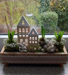 a window sill with plants and houses on it