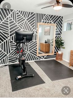 a bike is parked in front of a mirror on the floor next to a mat