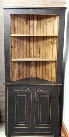 an old fashioned black bookcase with wooden doors and two cupboards on each side