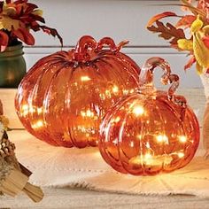 three glass pumpkins sitting on top of a table