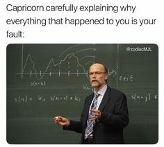 a man standing in front of a blackboard with writing on it that says capricon carefully explaining why everything is happening