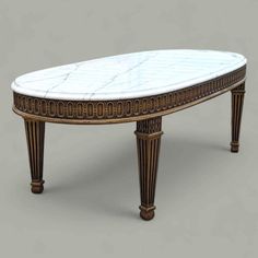 a marble top coffee table with gold trimmings and an intricately carved design