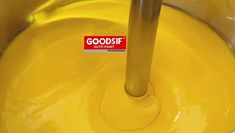 there is a sticker on the bottom of a yellow liquid in a bowl with bananas