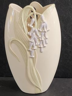 a white vase that has some kind of decoration on the inside of it's face