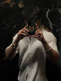 a man taking a selfie in front of a mirror with his cell phone up to his face