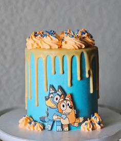 a blue and yellow cake with cartoon characters on it