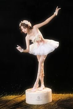 a young ballerina is posing on a pedestal