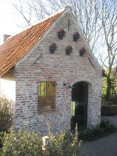 an old brick building with a red tiled roof and windows on the side of it