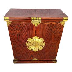 a wooden box with gold trimmings on the front and sides, sitting against a white background