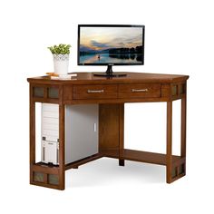 a computer desk with a monitor on top of it and drawers under the desk area