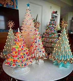 three small christmas trees sitting on top of a table