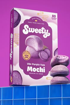 a box of sweety purple yum mochi sitting on top of a blue tile wall