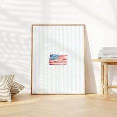 an american flag is displayed in front of a white wall with pillows and a wooden frame