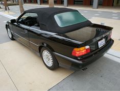 a black convertible car parked on the side of the road