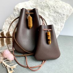 "Vegan Eco Leather Medicine Bag, Shaman Bag or Amulet Pouch to wear around your neck-or hang in your Car! Perfect for Ceremony or for Festival Wear. Dark Chocolate Faux Leather with a Tiger Eye Healing Stone Point. The Large size has a Double Terminated Stone! Unique and Beautiful Gift . A place for things that have Spiritual Meaning for you-like that pretty rock your 3 year old gave you.... Two Choices: Small:3 3/4\"deep 2 3/4\"wide Large:5 1/4\"deep 4\"wide BUY ANY 4 MEDICINE BAGS(VEGAN LEATHE Leather Pouch Bag With Card Slots, Brown Crossbody Pouch With Dust Bag, Everyday Portable Brown Pouch, Brown Leather Coin Purse, Brown Everyday Pouch, Brown Coin Purse For Mobile Phone Daily Use, Small Brown Bags For Everyday Use, Brown Mobile Phone Bag Coin Purse For Daily Use, Brown Mobile Phone Coin Purse For Daily Use