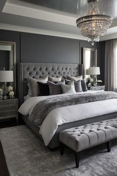 a bedroom with a large bed and a chandelier hanging from it's ceiling