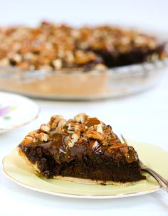 a slice of chocolate pie on a plate with a fork in front of the pie