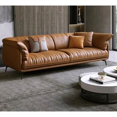 a brown leather couch sitting in a living room next to a table