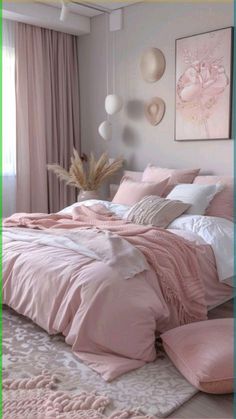 a bed with pink comforters and pillows in a bedroom next to a painting on the wall