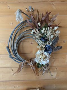 a wreath made out of rope and flowers on top of a wooden floor next to a pair of shoes