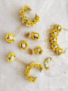 a bunch of flowers that are sitting on a white surface with pearls and beads around them