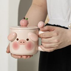 a person holding a pig mug in their hands