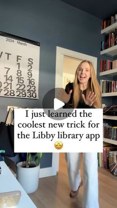 a woman standing in front of a book shelf with a sign that says i just learned the coolest new trick for the libby library app