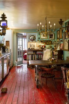 a dining room table and chairs in front of a doorway with pictures on the wall