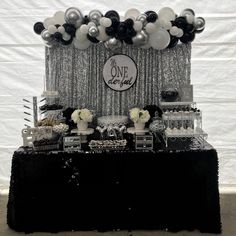 a black and white dessert table with balloons