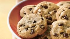 a bowl filled with chocolate chip cookies on top of a table