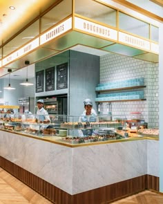 two chefs working behind the counter in a restaurant