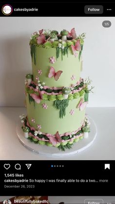 a three tiered green cake with pink butterflies on it's top and bottom