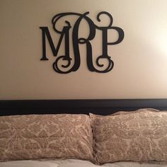 a monogrammed wall hanging above a bed