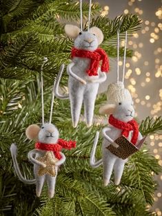 three ornaments hanging from a christmas tree in the shape of mice with hats and scarfs