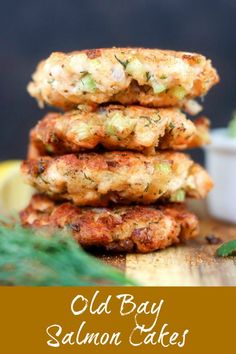 three crab cakes stacked on top of each other next to a small bowl of sauce