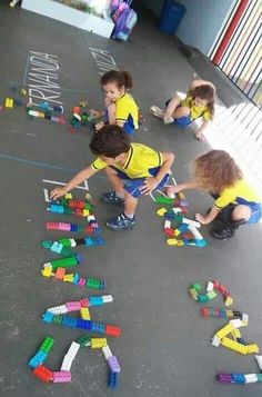 three children playing with legos on the floor