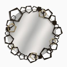 a round mirror with black and gold geometric shapes on it's sides, in the shape of hexagonals