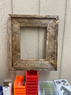 a wooden frame sitting on top of a table next to some boxes and other items